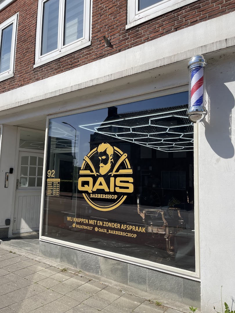 Het echte logo van Barbershop Qais op het raam en de rood-wit-blauwe barbierpaal aan de gevel op de Boulevard in Roosendaal